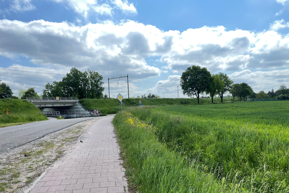 De Geuzendijk met de tunnel onder het spoor. Rechts het weiland dat de nieuwe beoogde locatie voor de islamitische begraafplaats is.