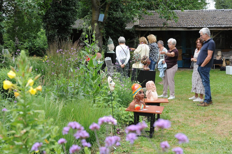 Bezoekers bekijken de kunstwerken in de tuin van zorgboerderij Dubbroek. 