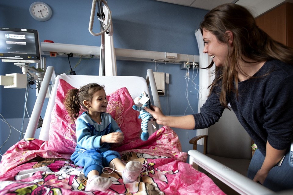 De 4-jarige Djamilla van Son krijgt in het Zuyderland ziekenhuis in Heerlen knuffel Zuydie toegestopt door medisch pedagogisch zorgverlener Melissa Zwart. 