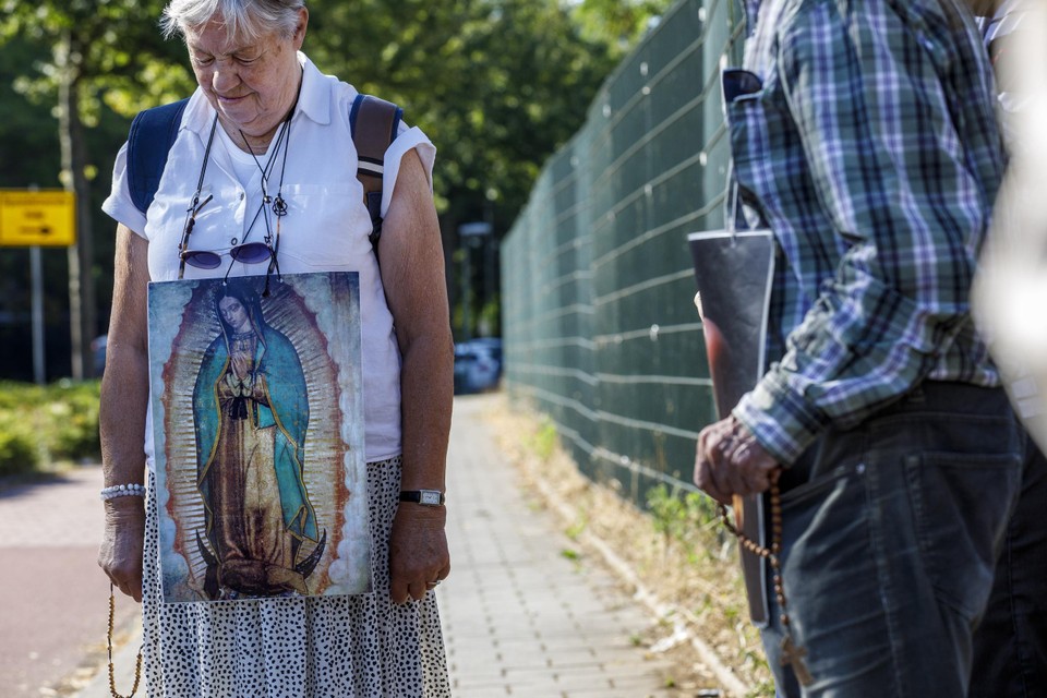 Een oudere dame draagt de afbeelding van de Maagd van Guadalupe om haar schouders. 