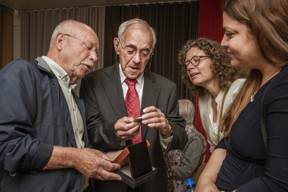 (V.l.n.r.) De neven Hein van Nienhuijs en Jos Winkel bekijken de Yad Vashem-medaille met een familielid en Karin Eliyahu Perry van de Israëlische Ambassade in Den Haag. 