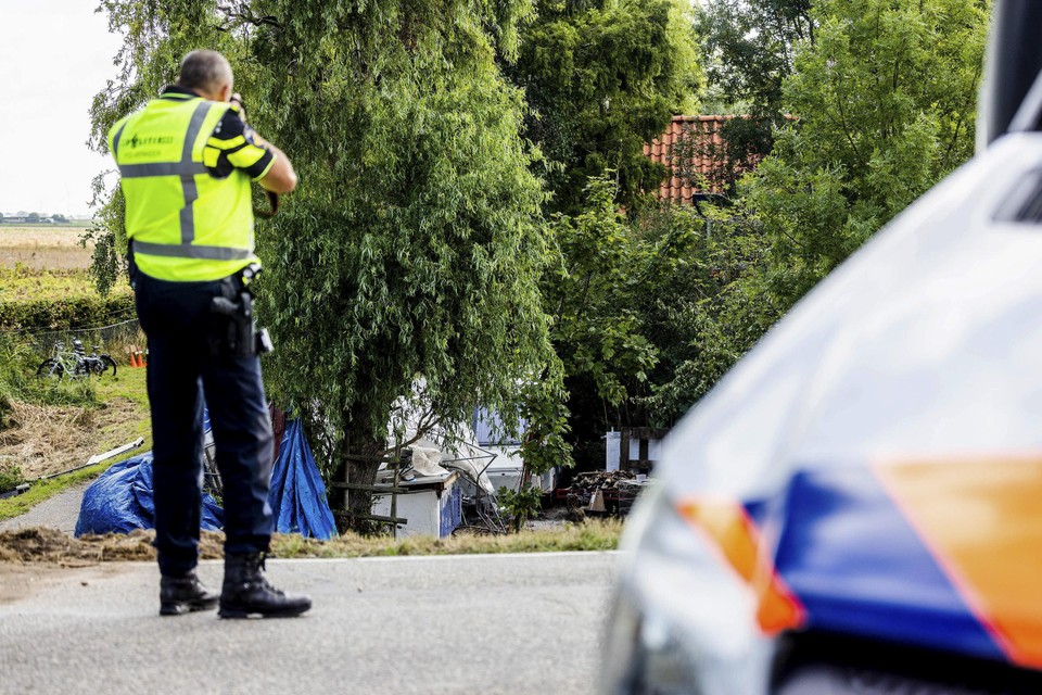 Een politieagent op de plaats van het ongeluk waar zaterdagavond een vrachtwagen vanaf een dijk op aanwezigen van een buurtfeest inreed.  