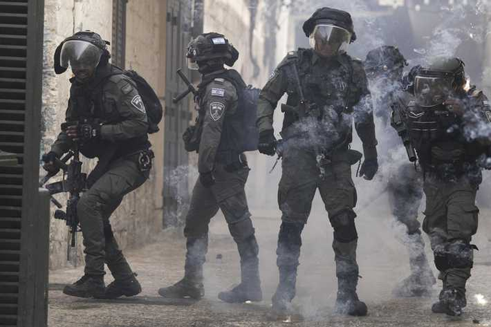 Palestijnse betogers gooien vuurwerk naar de politie. 