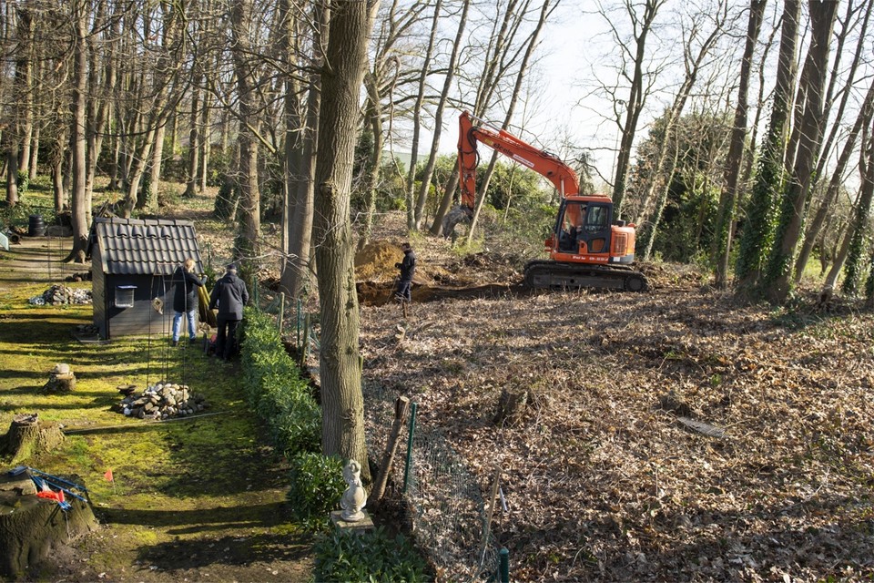 De struiken in het bosperceel aan de Kerstenbergweg in Beesel worden verwijderd, waarna een graafmachine de vrijgekomen grond systematisch afzoekt. 