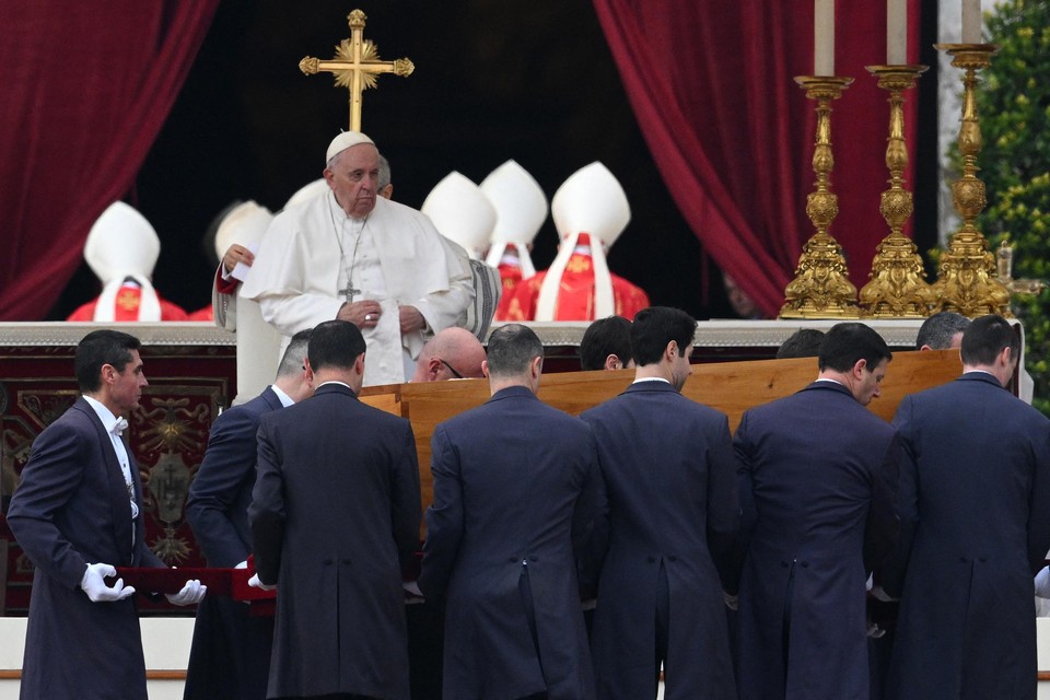 Paus Franciscus kijkt toe hoe de kist wordt weggedragen.