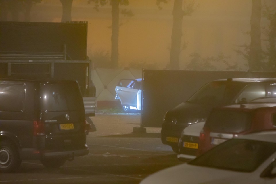 De witte Volkskwagen waarin donderdagavond de dode vrouw werd aangetroffen, wordt onderzocht en afgeschermd door de politie. 
