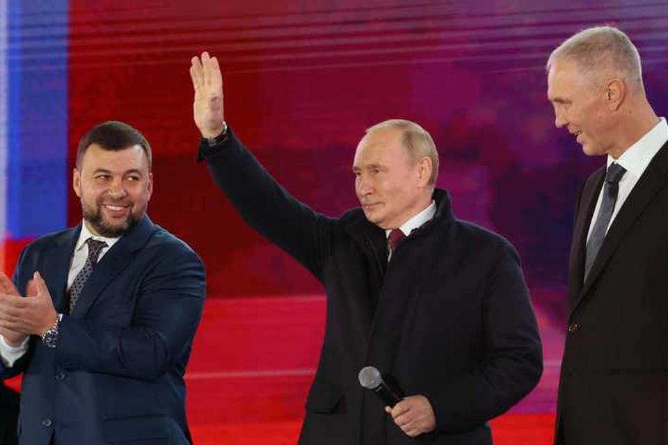 Een zwaaiende Vladimir Poetin afgelopen vrijdag, met links naast hem Denis Pushilin, de zelfverklaarde leider van de betwiste regio Donetsk in Oekraïne. De Russen vierden een feestje in Moskou vanwege de inlijving van meerdere gebieden. 