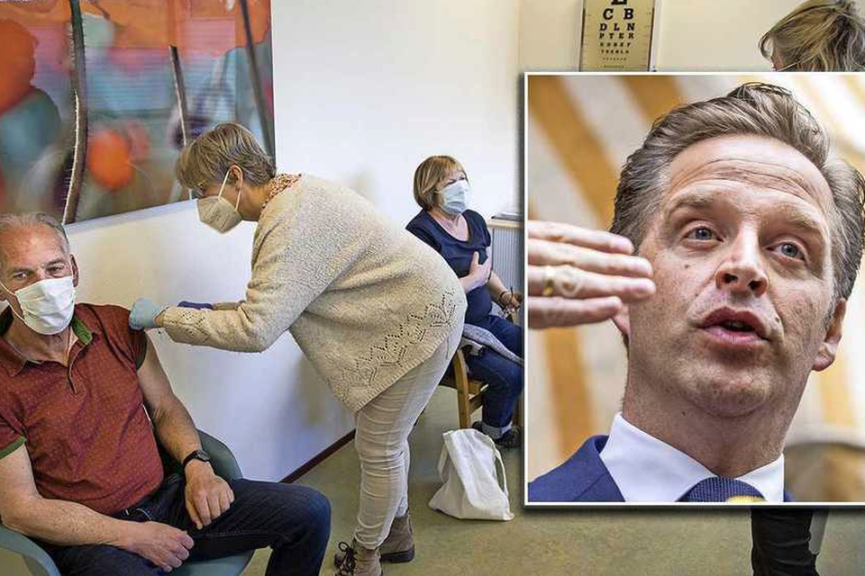 Een huisarts prikt een patiënt. Rechts minister Hugo de Jonge (inzet). 