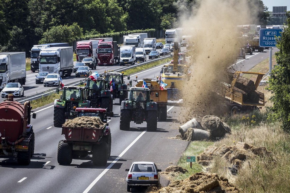 Boeren dumpen onder meer hooibalen en tractorbanden in de berm tijdens een protest op de A1. 