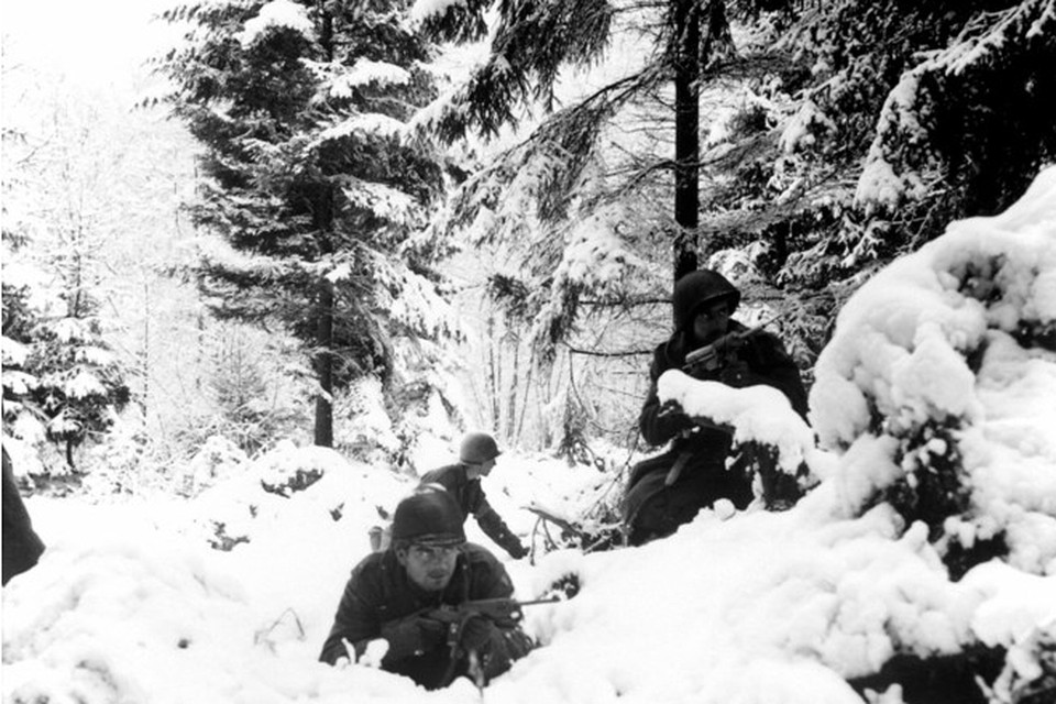 Amerikaanse soldaten zoeken dekking tijdens de Slag om de Ardennen. 