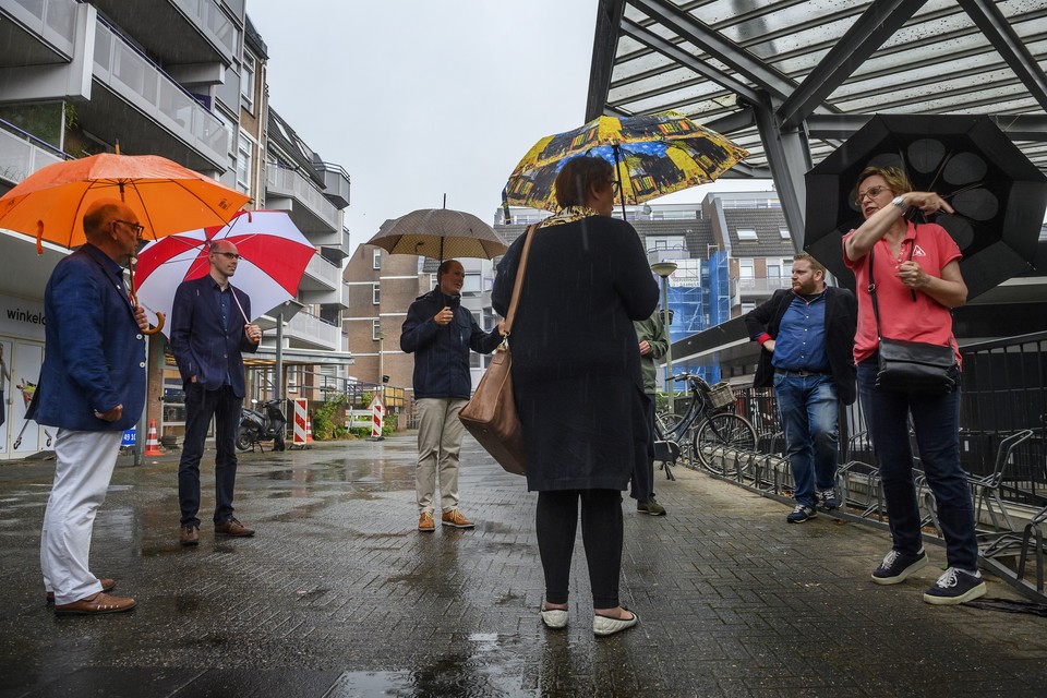 Raadsleden bezoeken het winkelcentrum in De Heeg (met rood-witte paraplu wethouder Gert-Jan Krabbendam).  
