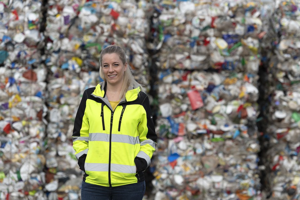 Eline Stiphout voor een berg huishoudelijk plastic afval. 