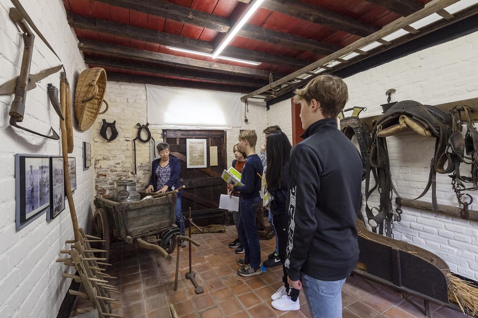 Leerlingen van Groenewald in de nostalgische stal van het Historiehuis van de Maasvallei in Elsloo. 