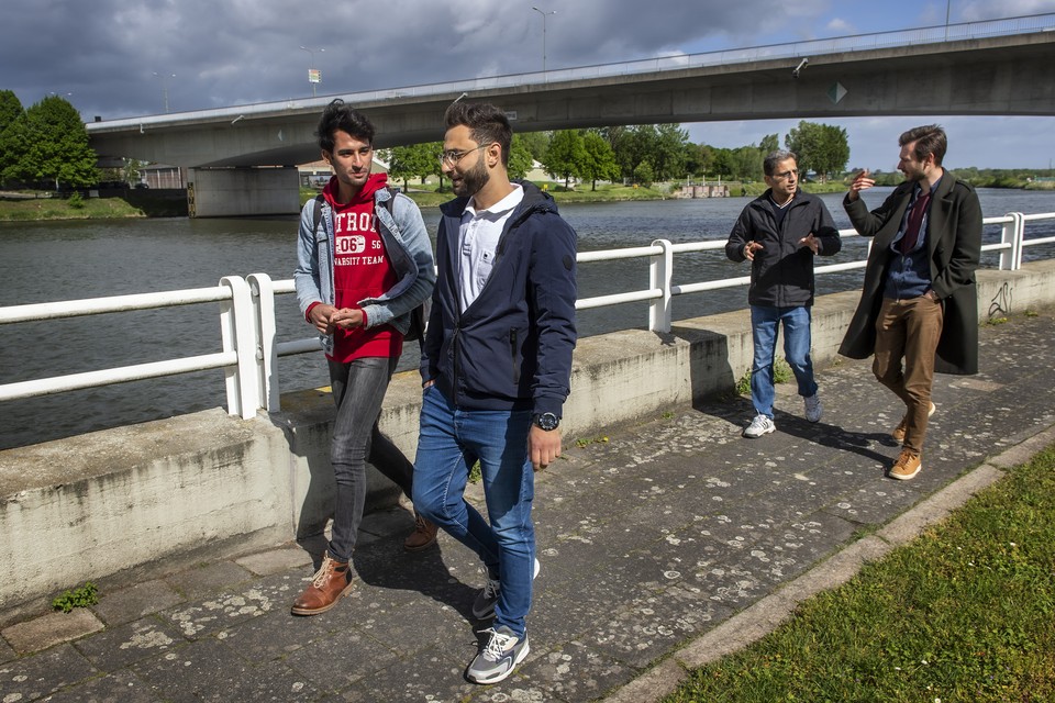 Studenten en asielzoekers samen onderweg: Ruben (links) en Yamen en op de achtergrond Eiad (links) en  Roger aan de wandel langs de Maas in Maastricht. 