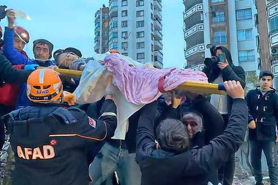 ulpverleners halen een kind uit het puin in de Turkse stad Adana.