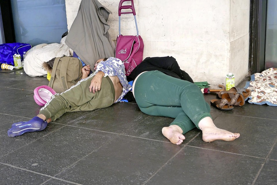 Daklozen slapen naast het station op straat. 