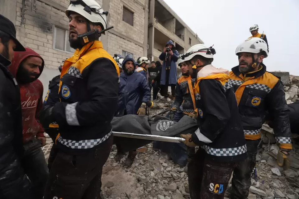 Reddingswerkers helpen bij het bergen van de slachtoffers van de aardbeving.