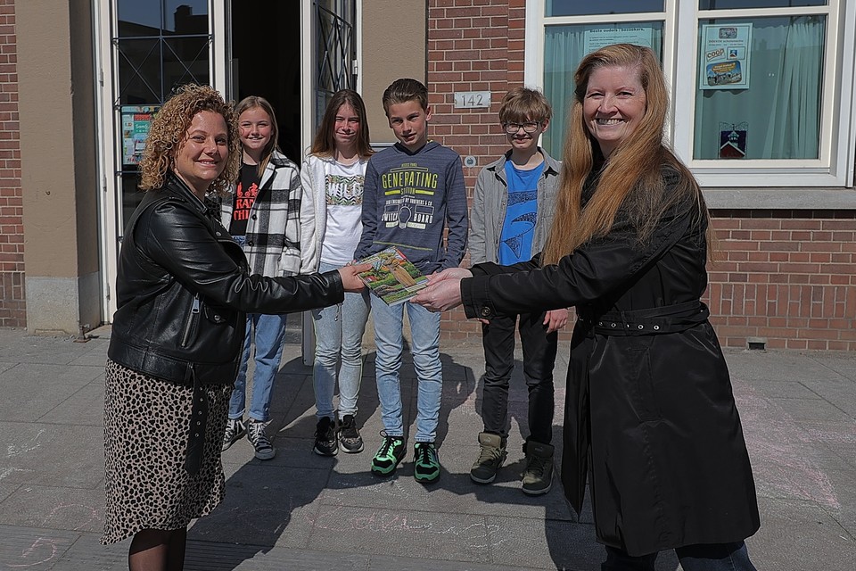 Gertie Schouwenberg (rechts) overhandigt het oorlogsboek aan directeur Monique Peeters van de Sint-Jozefschool.  