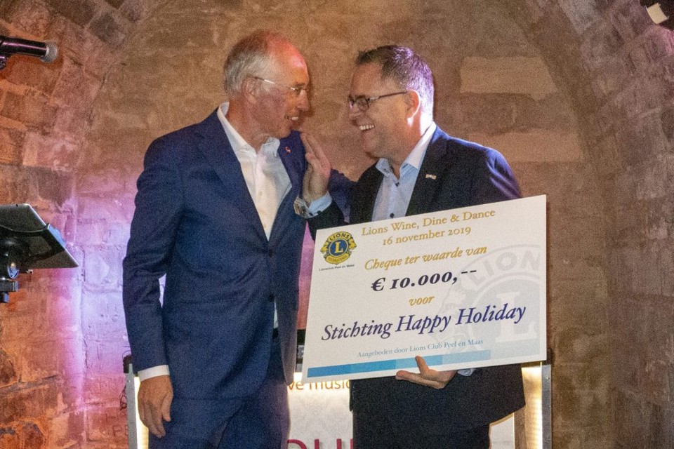 President Ruud Holthuis van de Lionsclub overhandigt de cheque aan John Grutters van Stichting Happy Holiday. 