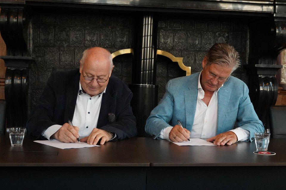 Wethouder John Aarts (links) en Leo van Vliet (rechts) tekenen de nieuwe overeenkomst. 