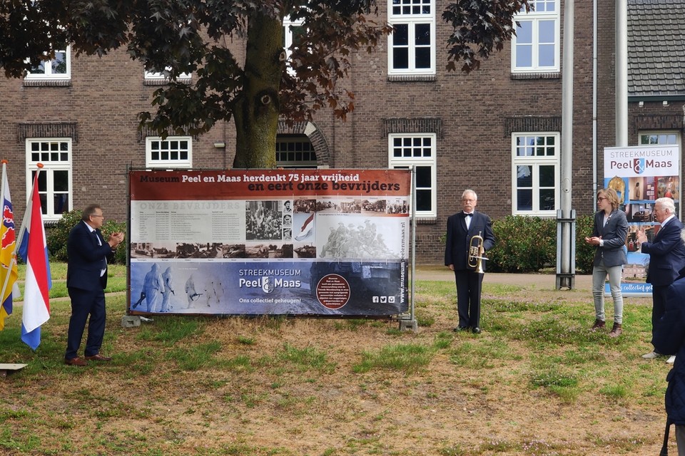 Voorzitter Henk van Dijck (links) van Museum Peel en Maas onthulde maandagmiddag samen met wethouder Wim Hermans (rechts) het spandoek in het teken van 75 jaar bevrijding. 