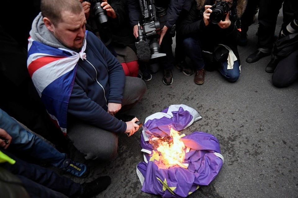 Een Brexitaanhanger steekt een Europese vlag in brand in het centrum van Londen. 