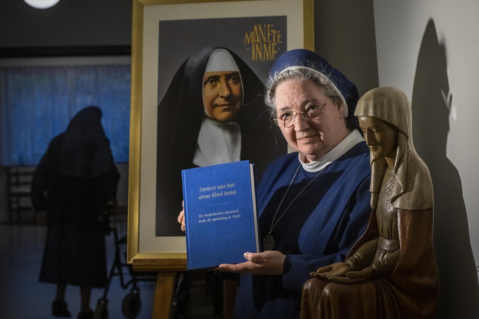 Moeder-overste Marie-Anne met het boek over de de 100-jarige historie van de congregatie Zusters van het Arme Kind Jezus in Nederland. 