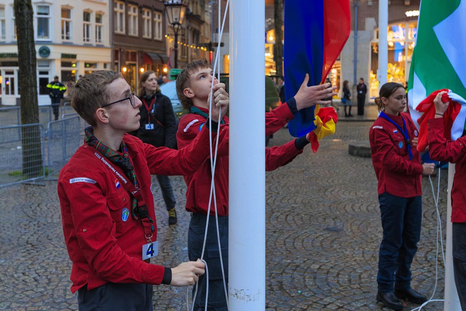 Riccardo Senden (l) tijdens het hijsen van de vlag op de Dam.
