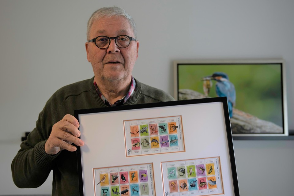 Hans Smulders toont de postzegelserie met de foto’s van zijn hand.  