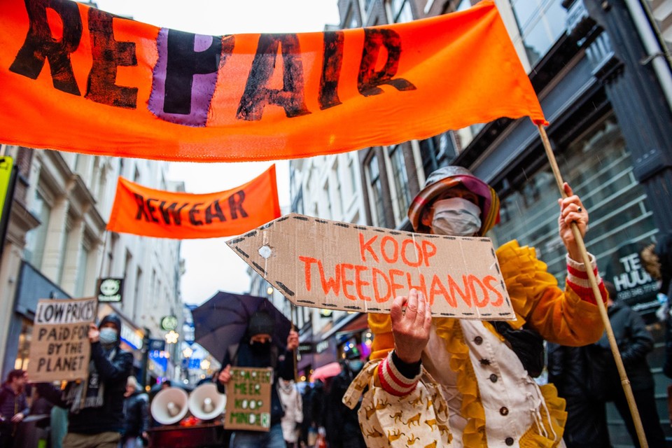 Demonstranten van Extinction Rebellion in Amsterdam pleiten voor reparatie en hergebruik van kleding en apparaten.