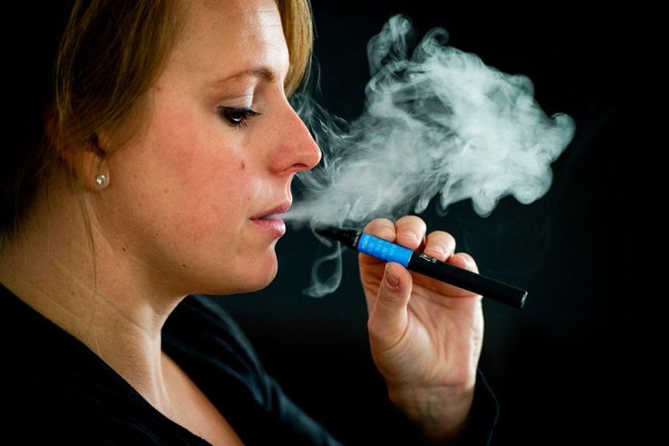 Een vrouw rookt een e-sigaret. De elektronische sigaret bestaat uit een wegwerpcartridge (refill) en een oplaadbare batterij. 