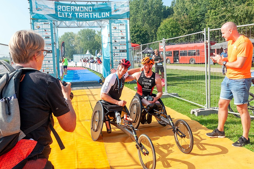 Paralympisch kampioen Jetze Plat (met rode helm) gaat zondag voor titelprolongatie tijdens het NK Para-Triathlon. Geheel rechts voorzitter Martijn Noldus.  