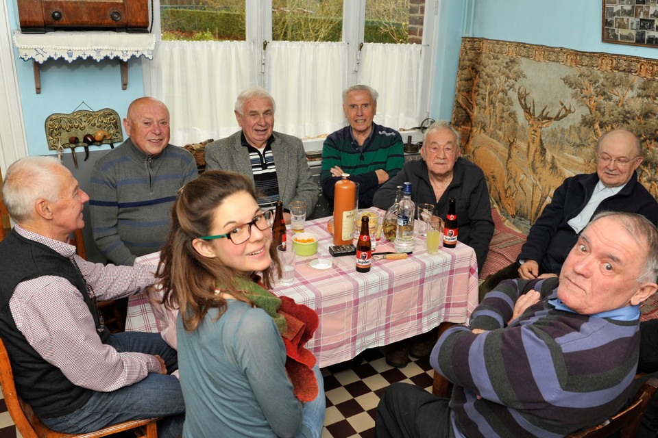 Nantke Pecht met zeven van de twaalf geïnterviewde oud-mijnwerkers uit Eisden die Cité Duits spreken aan tafel. Inmiddels zijn er nog maar negen in leven. 