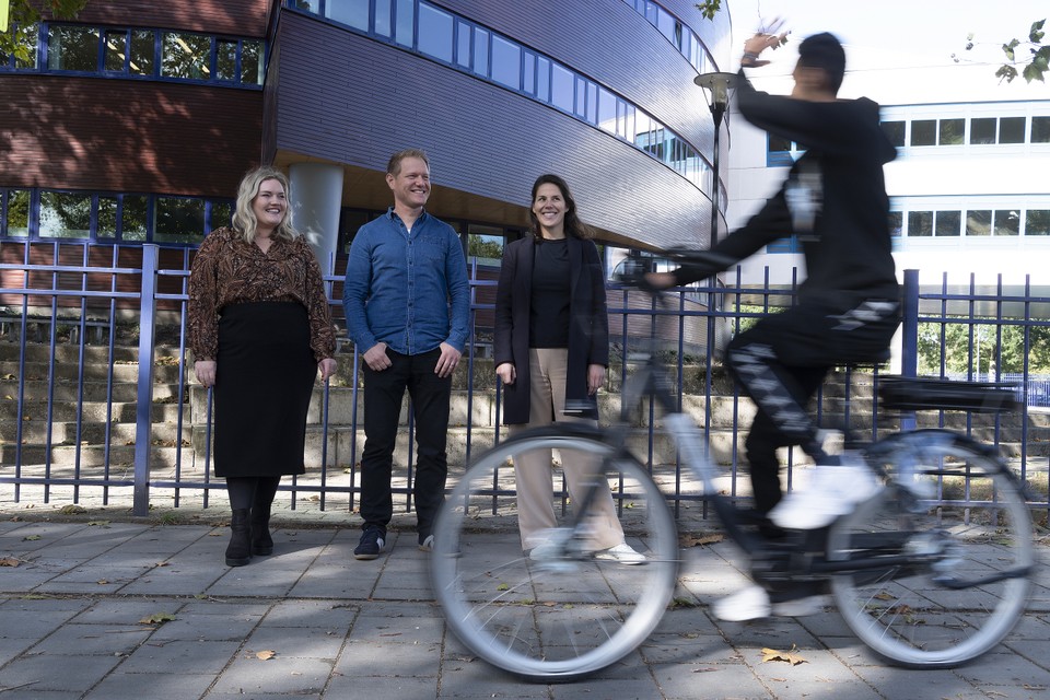 Cyrus (16) komt op zijn elektrische fiets aan bij het Trevianum in Sittard, waar zijn docenten Linda Keulen (L), Paul L’Ortye en Aukje Pelt hem op staan te wachten. 