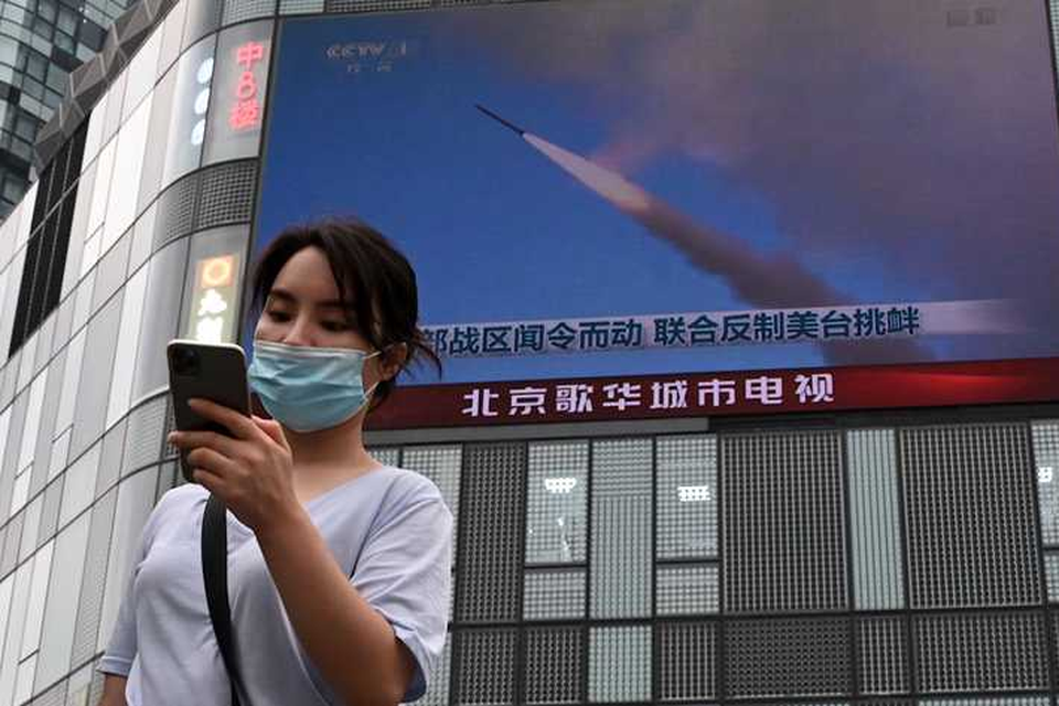 Een vrouw in Peking volgt het nieuws uit Taiwan op haar telefoon.