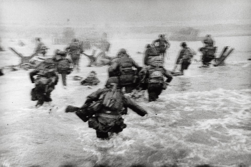 Een iconische foto die Robert Capa maakt van de landing op Omaha Beach in Normandië. 