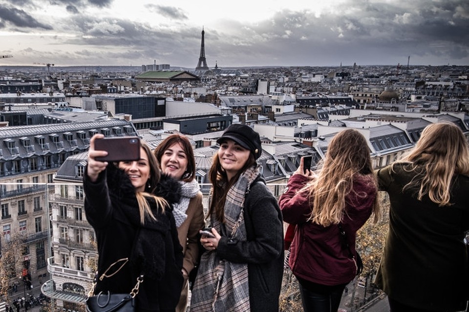Toeristen bekijken Parijs vanaf het panoramadak van het warenhuis Galeries Lafayette Paris Haussmann. 