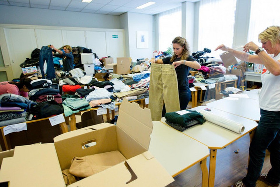 Foto ter illustratie. Vrijwilligers sorteren ingezamelde kleding voor vluchtelingen.