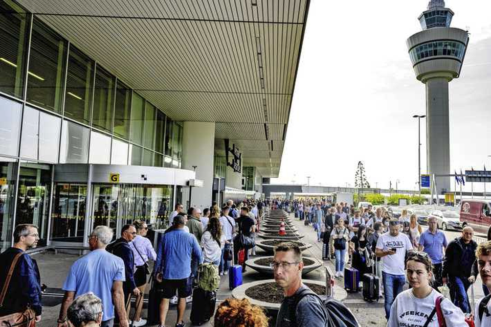 Lange rijen voor de vertrekhallen op luchthaven Schiphol afgelopen zomer.