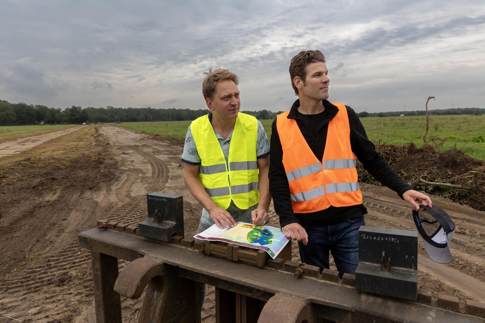 Bouke Sibbing (links) en Willem Broeders van Staatsbosbeheer op een net met zand dichtgegooide watergang aan de Mussenbaan.