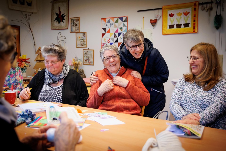 Bernie Peters (midden) wordt gefeliciteerd door een collega van de handwerkclub