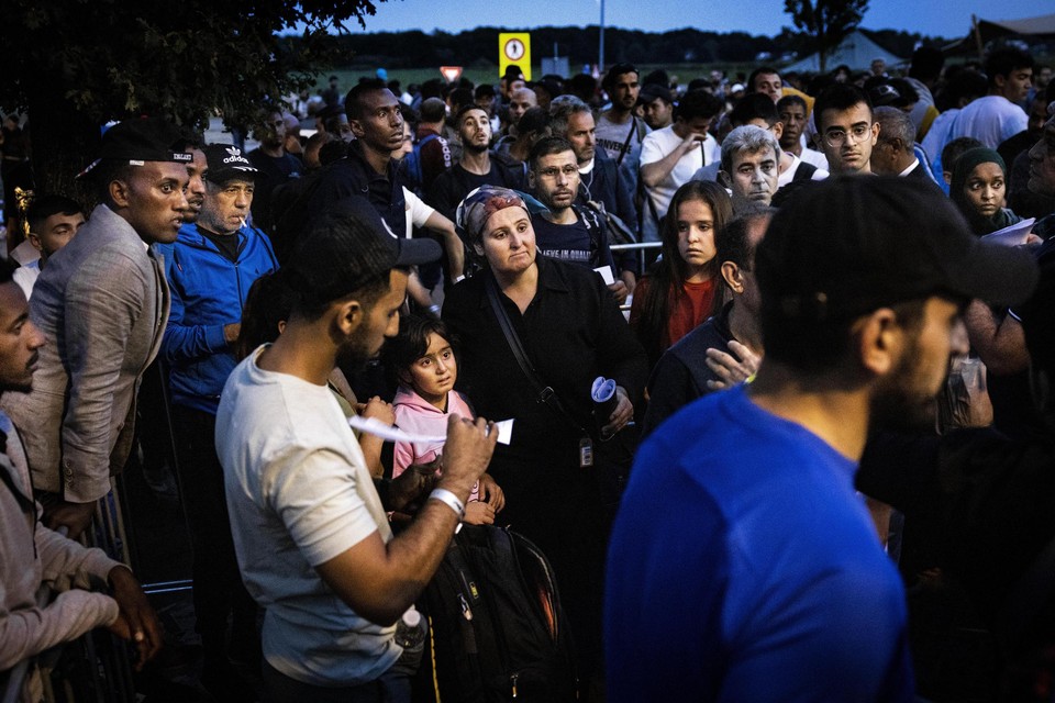 Vluchtelingen wachten buiten het aanmeldcentrum van de IND in Ter Apel.