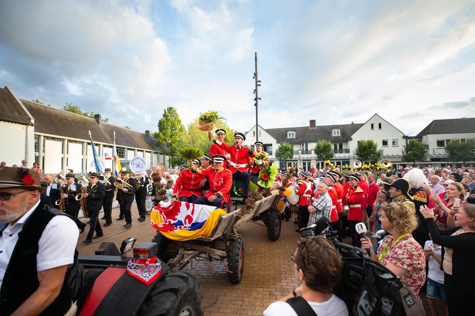 De schutters gaan op de platte kar door Born. 