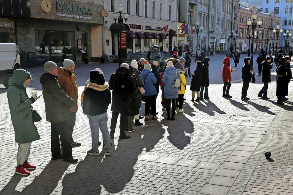 Mensen wachten in de rij om geld op te nemen bij een geldautomaat van de Tinkoff Bank in het centrum van Moskou. 