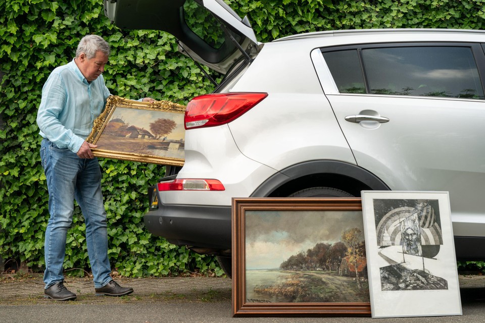 Ger Willems laadt enkele schilderijen voor de verkoopexpositie in zijn auto.