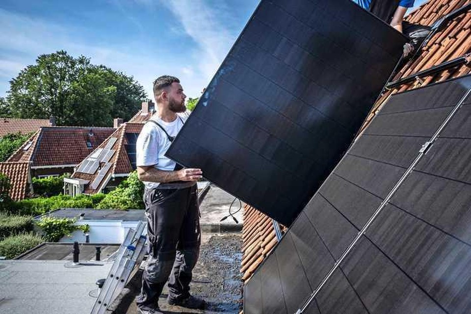 Op het dak van een huis in het Groningse Haren worden zonnepanelen geplaatst.