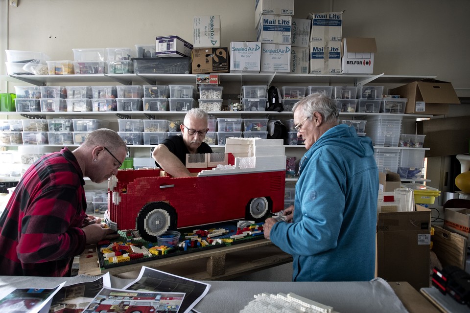 Geert Renselaar (midden) bouwt met zijn vrienden aan een grote Lego-camper. 
