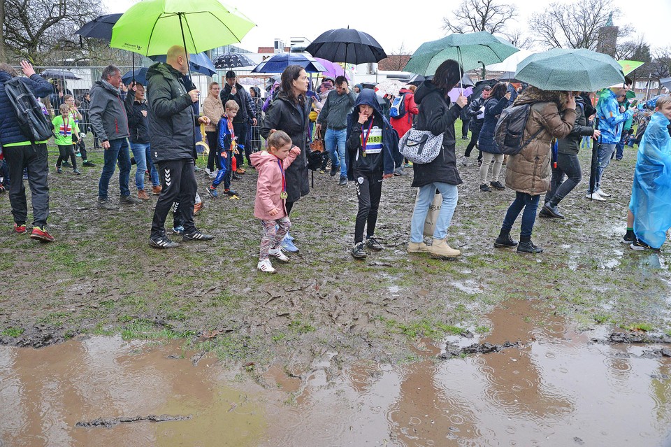Door de vele regen moet het publiek door de modder ploeteren.