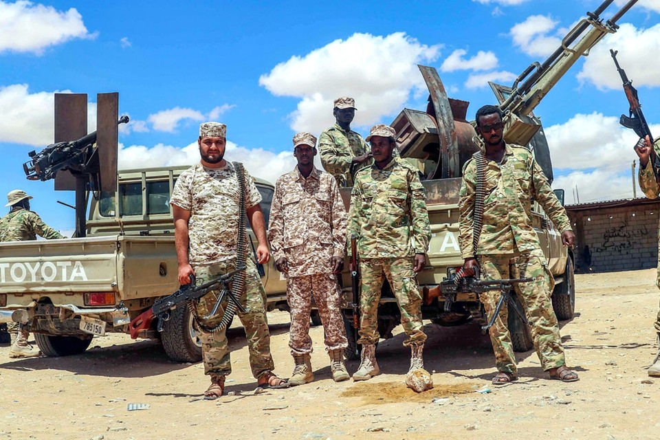 Soldaten van het Libische nationale leger poseren langs de weg tussen Tripoli en Benghazi. 