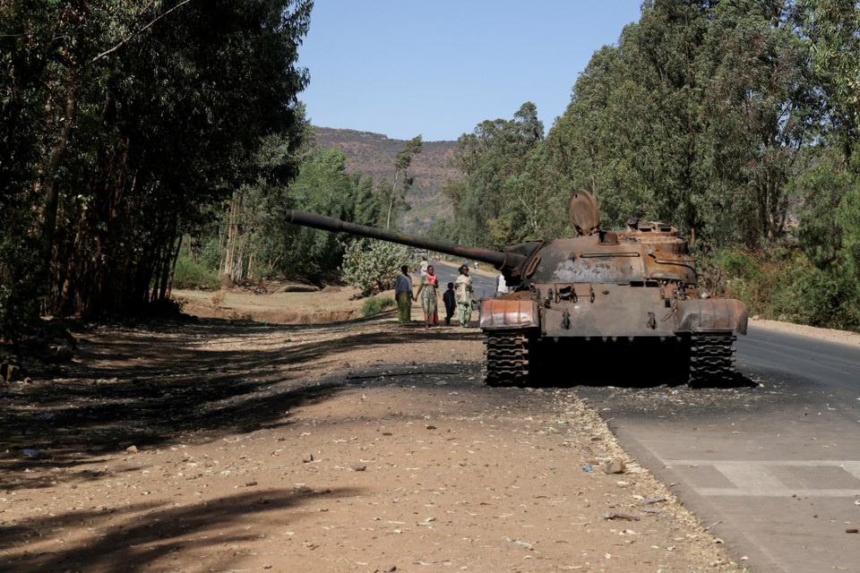 Vrouwen en kinderen passeren een uitgebrande tank van het Ethiopische leger in de provincie Tigray. 
